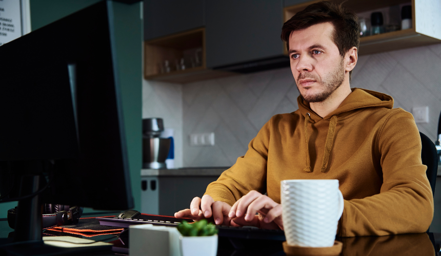 Hybrides Arbeiten eines jungen Mannes im Homeoffice